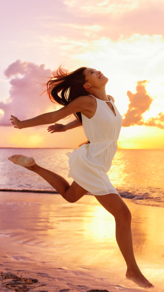 whatr do longevity doctors do - woman dancing on the beach in a sunset