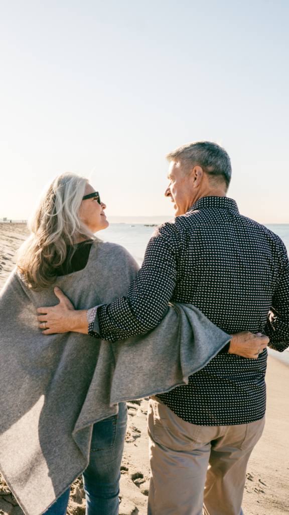 what do longevity doctors do? Mature couple walking on the beach