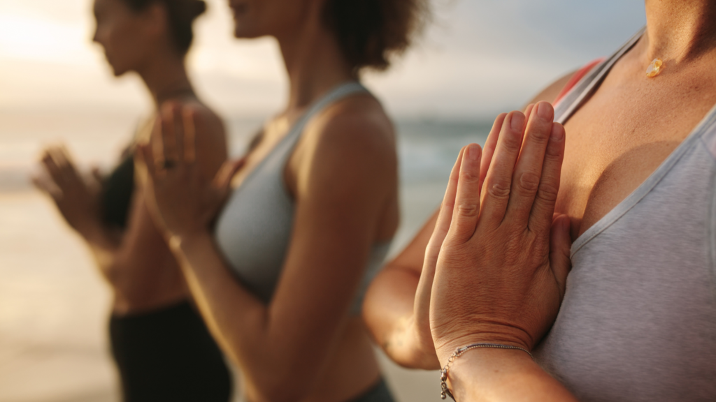 What do longevity doctors do? People doing yoga on the beach